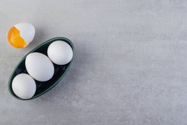 Taze beyaz tavuk yumurtaları taştan bir arka plana yerleştirilmiş. Yüksek kalite fotoğraf