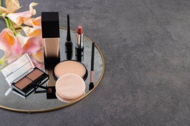 Masada suni çiçekli ve aynalı dekoratif kozmetik ürünler. Yüksek kalite fotoğraf