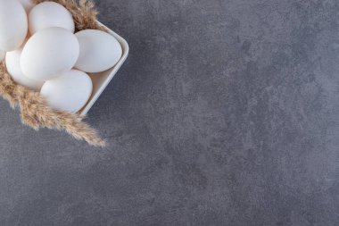 Taze beyaz tavuk yumurtaları taştan bir arka plana yerleştirilmiş. Yüksek kalite fotoğraf