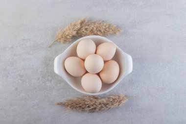 Taze beyaz tavuk yumurtaları taştan bir arka plana yerleştirilmiş. Yüksek kalite fotoğraf