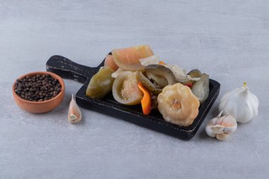 Taş zeminde çeşitli mayalanmış sebzelerden oluşan ahşap tahta bir tahta. Yüksek kalite fotoğraf