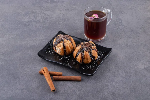 Cookies with chocolate coating and a glass cup of black tea . High quality photo