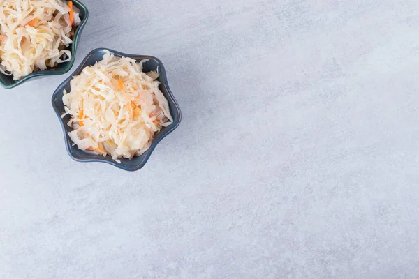 Taş masaya iki kase lezzetli lahana turşusu. Yüksek kalite fotoğraf