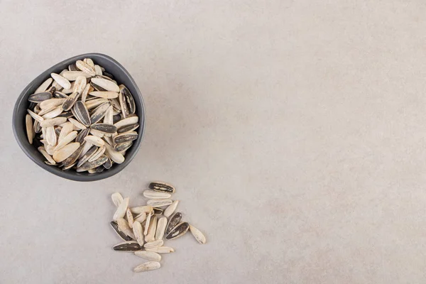 Delicious sunflower black seeds placed on beige table. High quality photo