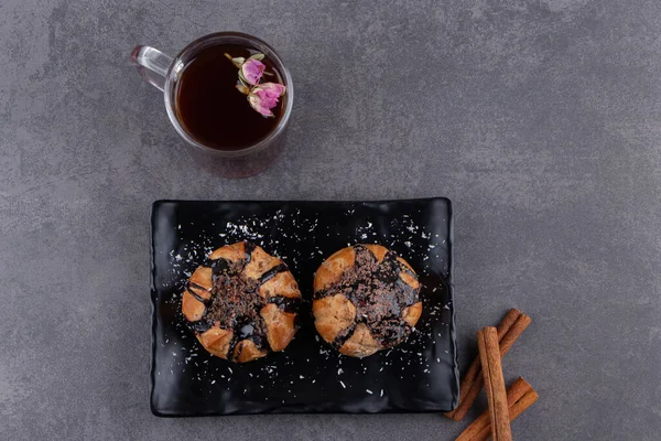 Cookies with chocolate coating and a glass cup of black tea . High quality photo