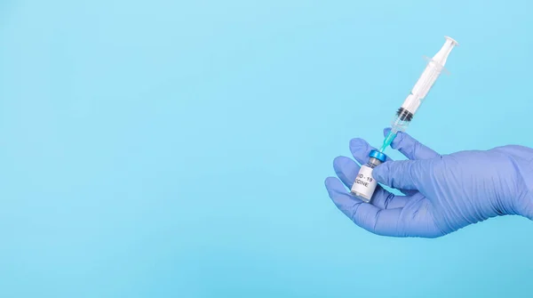Banner. Lékař má rukavice držící injekční stříkačku s testováním vakcíny a připravuje se na injekci. Očkování COVID-19. — Stock fotografie
