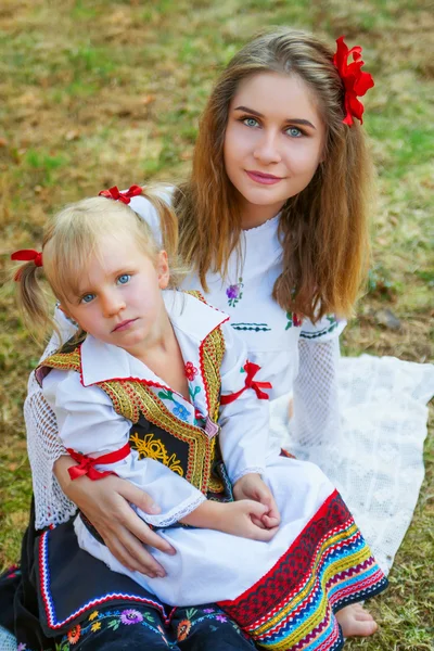 Joven mujer y niña posando con ropa tradicional serbia — Foto de Stock