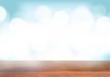 Mavi arka plan üzerinde bulanık ışıkları ile ahşap masa.