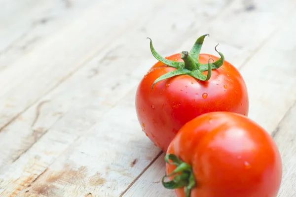 Primer plano de tomates frescos y maduros sobre fondo de madera. — Foto de Stock