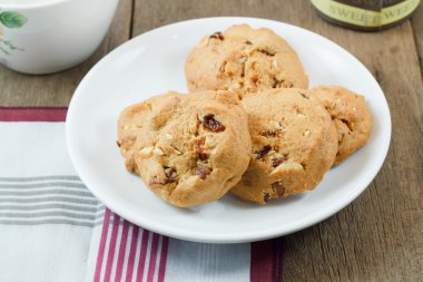 Çikolatalı kurabiye beyaz disk üzerinde ahşap masa