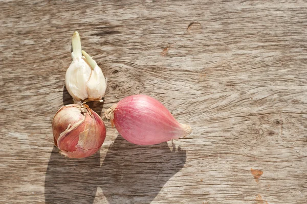 Červená cibule na dřevěný stůl. — Stock fotografie