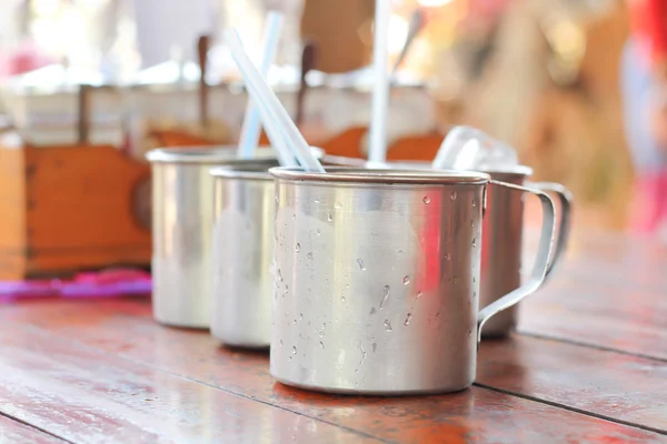 Drink water in metalen cup op Thailand noedels winkel. — Stockfoto