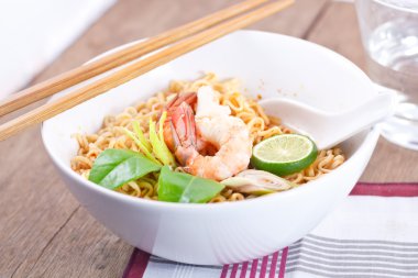 Ahşap masa üzerinde sıcak ve baharatlı anlık erişte.