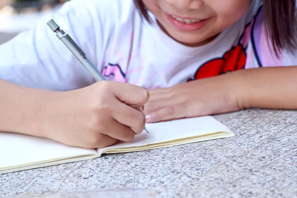 Kinderen tekenen op haar opmerking boek. — Stockfoto