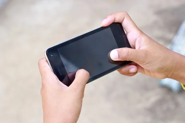 Руки касаясь смартфона яркий фон, крупным планом — стоковое фото