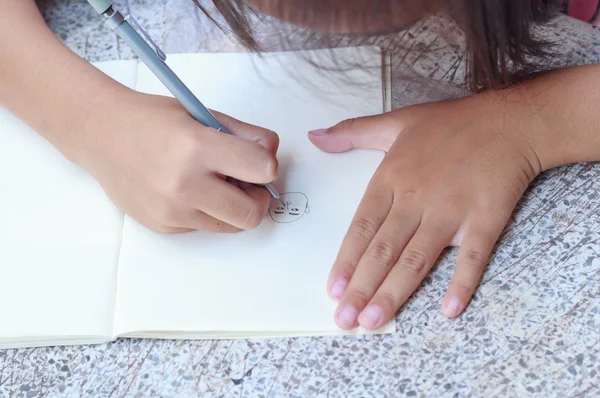 Kinderen tekenen op haar opmerking boek. — Stockfoto