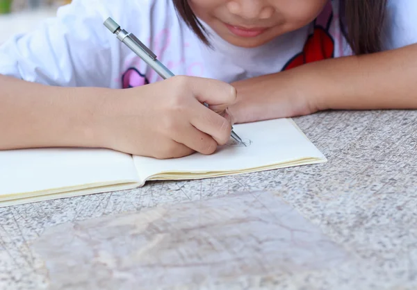 Kinderen tekenen op haar opmerking boek. — Stockfoto