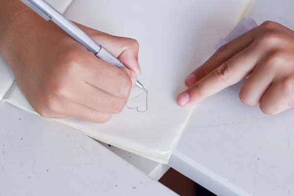 Niños dibujando un grito de corazón en su libreta . —  Fotos de Stock