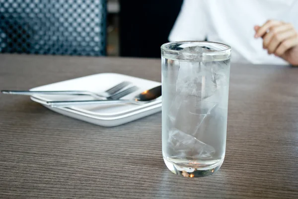 Verre d'eau potable dans le cadre de la table au déjeuner . — Photo