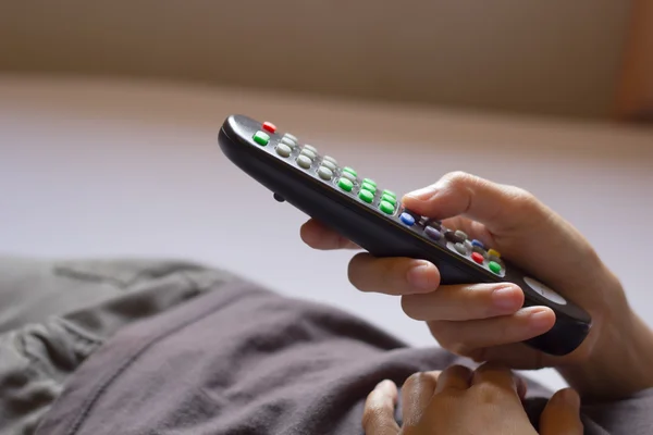 Ver la televisión y usar el mando a distancia. — Foto de Stock