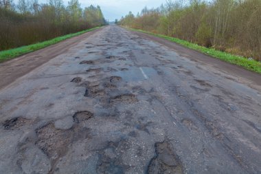 Büyük çukurlar ve asfalt'ın yol üzerinde delik.