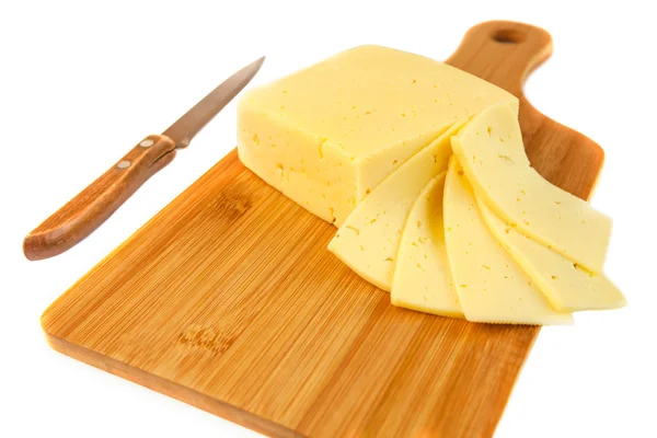 Bloque de sabroso queso y rebanadas en tabla de cortar con un cuchillo, aislado sobre fondo blanco —  Fotos de Stock