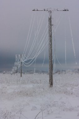 Kırık faz elektrik hatları ile ahşap elektrik direklerine kırsal kış fırtına sonra üzerinde hoarfrost