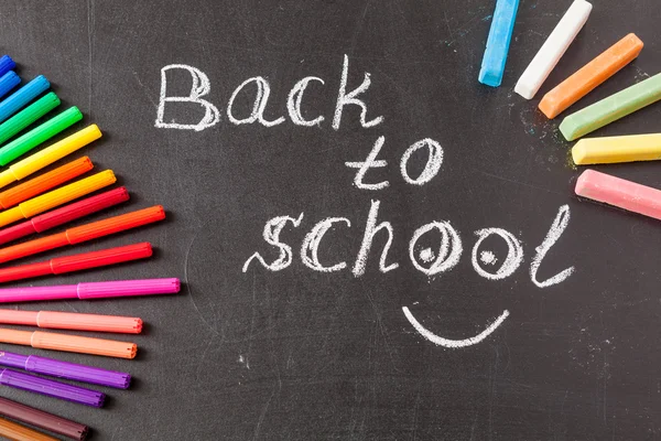 Назад до школи з барвистими фетровими наконечниками та заголовком "Назад до школи", написаними білою крейдою — стокове фото