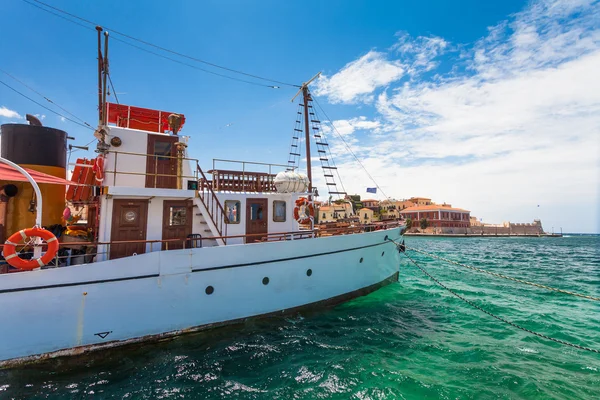Chania, Creta - 26 de junio de 2016: El viejo barco para cruceros diarios en el terraplén del casco antiguo de Chania y el faro, Creta — Foto de Stock