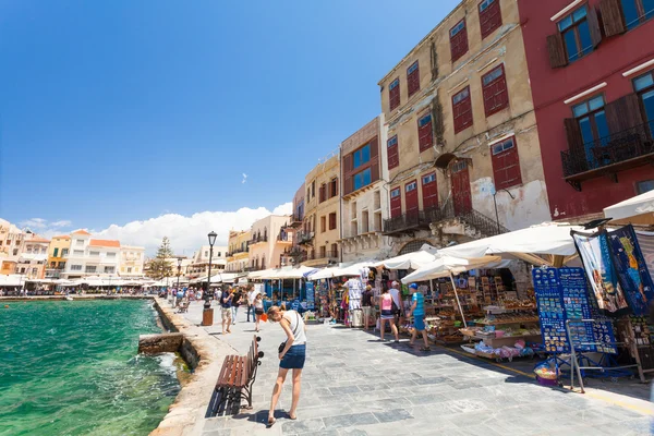 Chania, Creta - 26 de junio de 2016: Los turistas y la arquitectura del casco antiguo con tiendas con recuerdos se encuentran en el terraplén del casco antiguo de Chania, Creta . — Foto de Stock