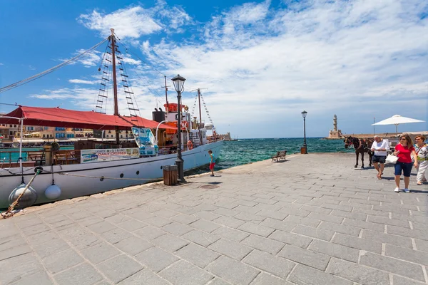 Chania, Creta - 26 de junio de 2016: El viejo barco para cruceros diarios en el terraplén del casco antiguo de Chania y el faro, Creta — Foto de Stock