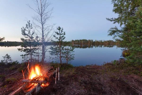 Bonfire on the bank of lake early morning