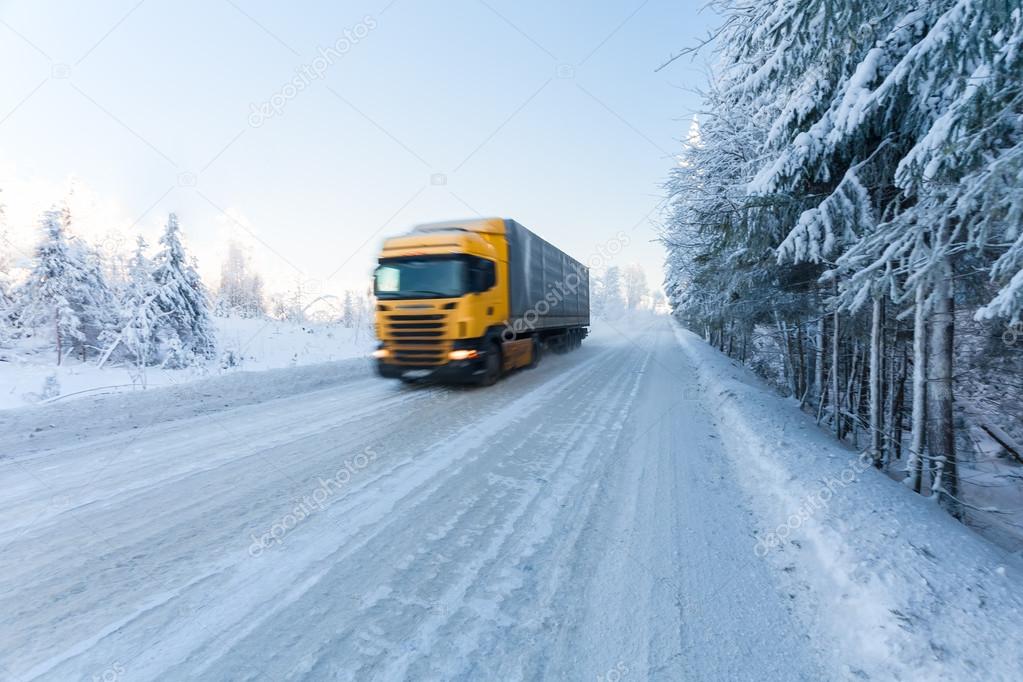 Motion blur of a  truck on winter road on frosty day