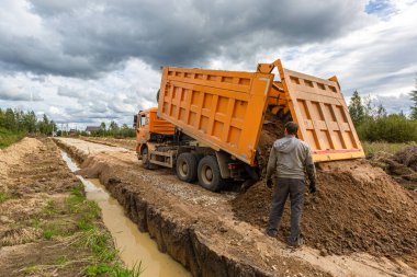 İnşaat sırasında inşaat kamyonu devrilmiş ya da yola kum dökmüş. Çöp kamyonu boşaltma işlemi..