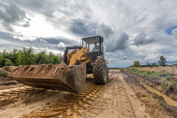 Costruzione stradale e uno dei macchinari da costruzione bulldozer è appiattisce la sabbia sulla strada prima di asfaltare. — Foto Stock