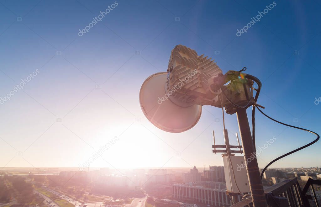 Radio antennas with outdoor radio unit and power cables, coaxial cables, optic fibers on the metal construction for telecommunication data equipment or mast in city. Outside part of telecommunication