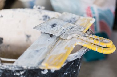 Dairenin zemininde macun ve macun bıçağı olan kova yapım, yenileme, yenileme, uzatma, restorasyon ve yeniden yapılanma aşamasında.