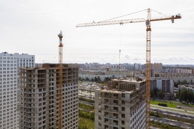 İnşaat tesisinde çalışan vinçler, işçiler, inşaat malzemeleri ve aletler de dahil olmak üzere büyük inşaat sahası