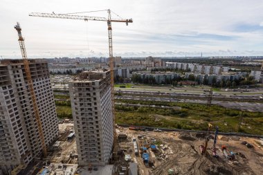 İnşaat tesisinde çalışan vinçler, işçiler, inşaat malzemeleri ve aletler de dahil olmak üzere büyük inşaat sahası