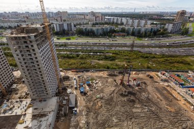İnşaat tesisinde çalışan vinçler, işçiler, inşaat malzemeleri ve aletler de dahil olmak üzere büyük inşaat sahası