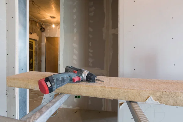 Werkproces van het installeren van metalen frames voor gipsplaten -gipsplaten - voor het maken van gipsplaten muren in appartement is in aanbouw, verbouwing, renovatie, uitbreiding, restauratie en wederopbouw. Stockfoto