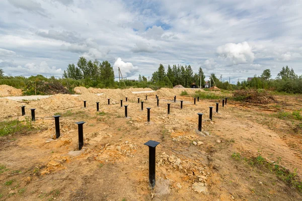 IJzeren schroeven stapels in de grond voor een nieuw gebouw op de bouwplaats. Rechtenvrije Stockfoto's