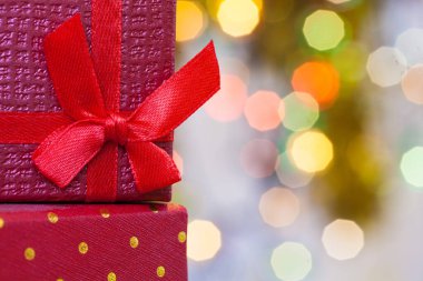 Kırmızı kurdeleli Noel hediyeleri ve soyut tatil arkaplanlı Noel kutuları.