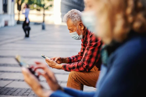 Senior Con Máscara Protectora Sentarse Banco Exterior Uso Teléfono Celular —  Fotos de Stock