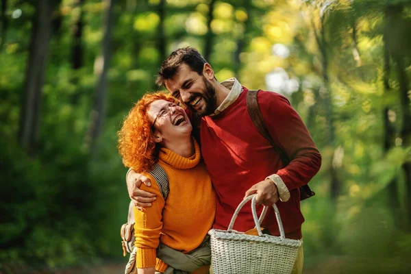 若い幸せな愛の抱擁と自然の中で歩くのカップル笑顔 カップルはピクニック用品を持っている 秋の時間 — ストック写真