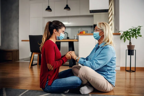 Moeder Dochter Met Beschermende Chirurgische Gezichtsmaskers Vloer Hand Hand Tijdens — Stockfoto