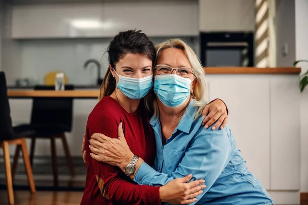 Mother Daughter Protective Surgical Face Masks Sitting Floor Hugging Corona — Stock Photo, Image