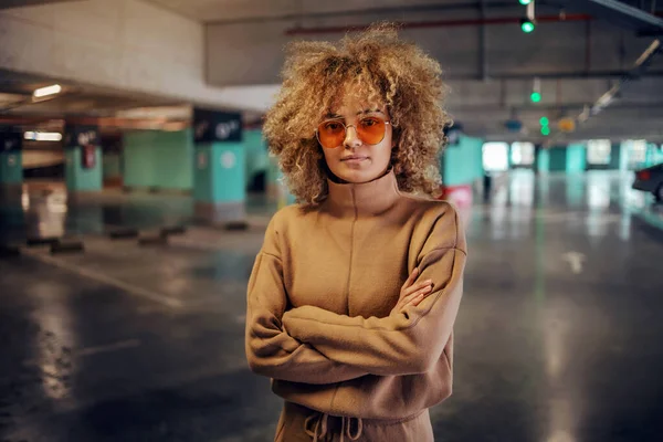 Jonge Modieuze Vrouw Met Krullend Haar Ondergrondse Garage Met Gekruiste — Stockfoto