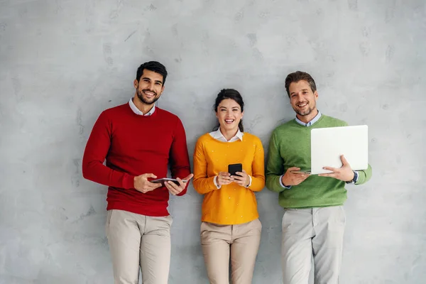 Three Business People Standing Wall Holding Various Gadgets Hands — Stockfoto