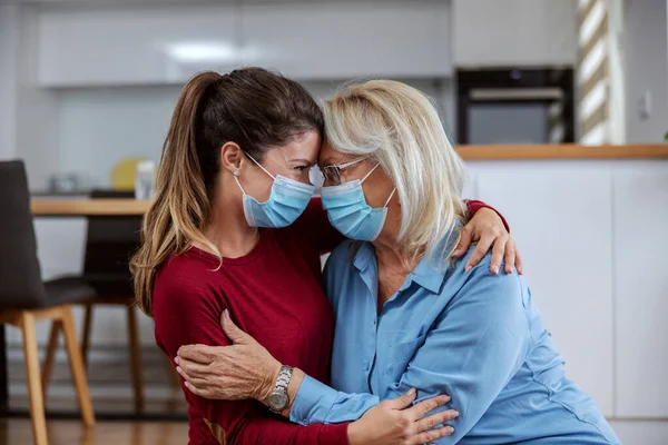 Mother Daughter Protective Surgical Face Masks Sitting Floor Hugging Corona — Stock Photo, Image